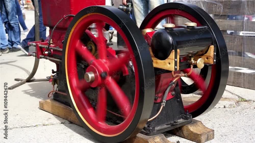 Rotating flywheels of retro steam engine at old cars exhibition, old