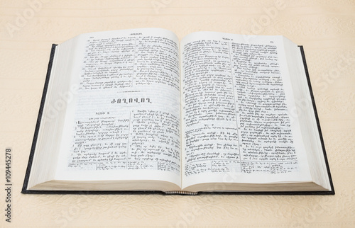 Bible is an open book with text on white paper background on the beige-pink color