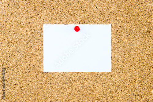 Blank white paper note pinned on cork board