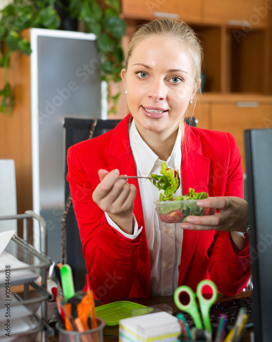 Businesswoman having lunch in office photo