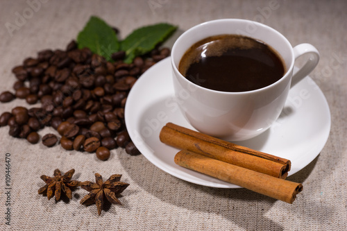 Full cup of coffee with cinnamon and spices