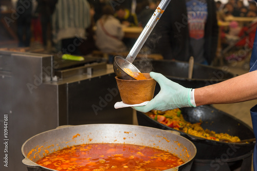 Obraz na płótnie Ladeling Spicy Soup from Large Pot into Bowl w salonie
