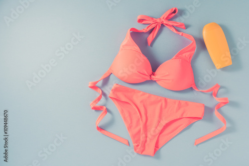 Quadro su tela Pink swimsuit on blue background