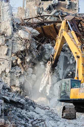 Excavator working at the demolition of an old industrial building.