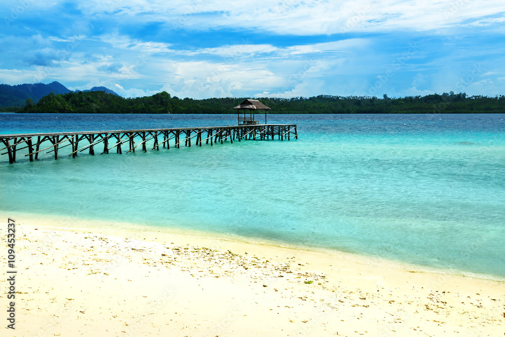 Beach and wooden dock on Bolilanga Island. Togean Islands. Indonesia.