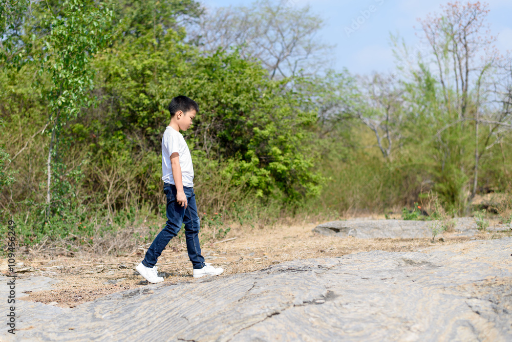 Fototapeta premium Boy walking on the rocky land.