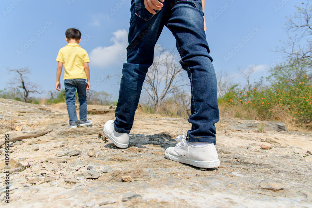 Two Boy walking on the rocky land.