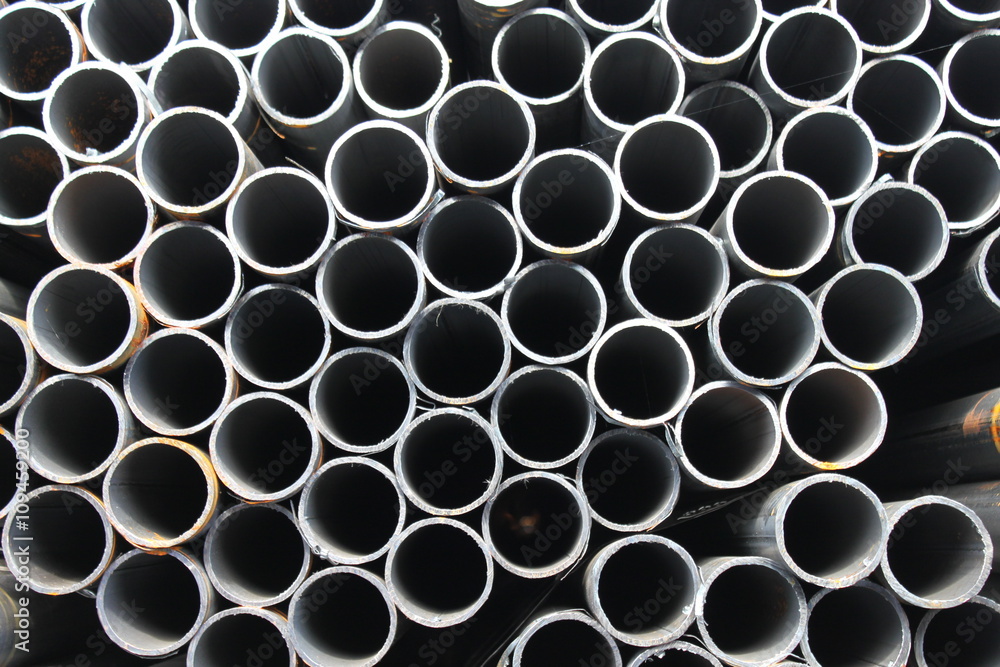 Steel tube. Metal pipe. Steel rolled bar. Stuck of steel pipes. Steel pipe bundle in industrial stockyard. Steel tube. Metal pipe. Steel rolled bar. Stuck of steel pipes. Steel pipe bundle in industrial stockyard.
