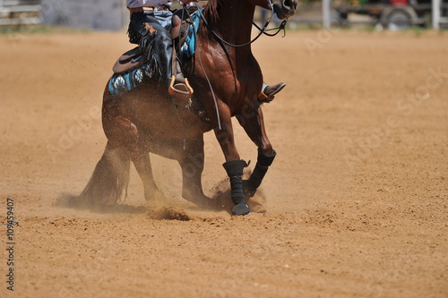A side view of a rider and horse running ahead in the dust. © PROMA