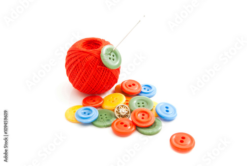 needle, plastic buttons and red thread