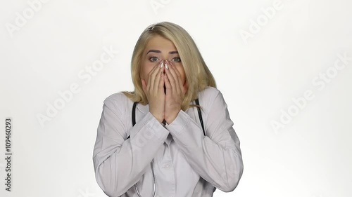 Shocked young female doctor. White. Slow motion photo