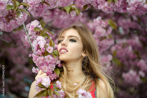 Beautiful young woman in blooming orchard