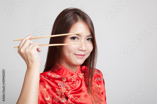 Asian girl in chinese cheongsam dress with  chopsticks