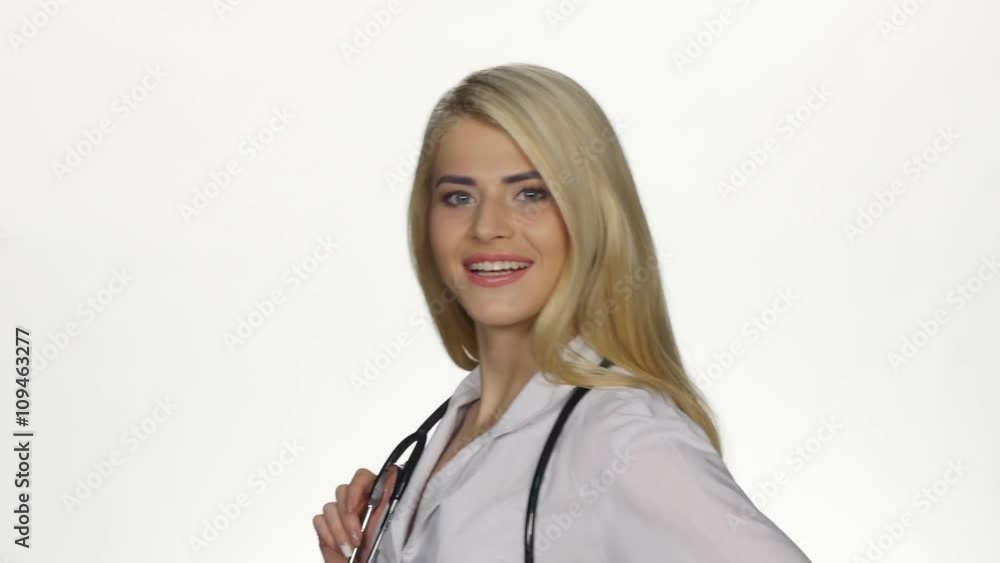 Female doctor with stethoscope smiling to camera. White Female doctor with stethoscope smiling to camera. White