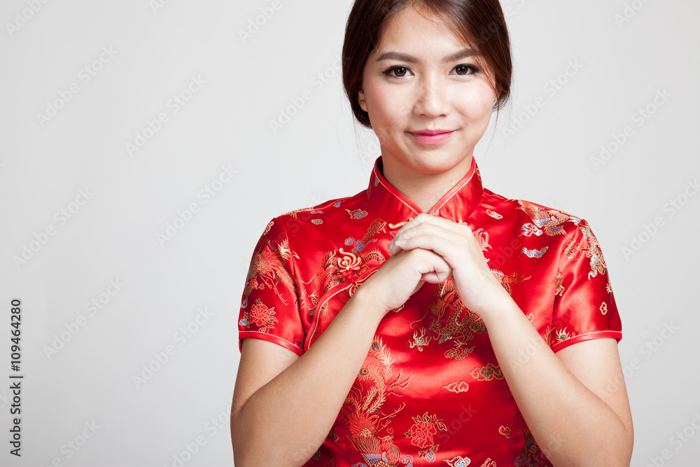 Asian girl in chinese cheongsam dress with gesture of congratula Asian girl in chinese cheongsam dress with gesture of congratula