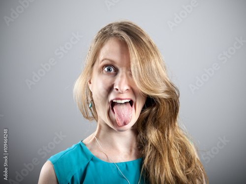 Mujer rubia sacando la lengua