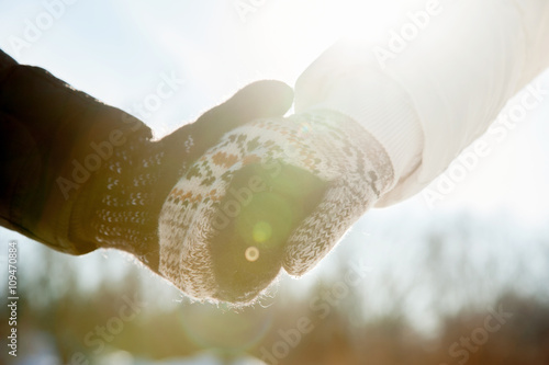 Couple holding hands in gloves in winter season