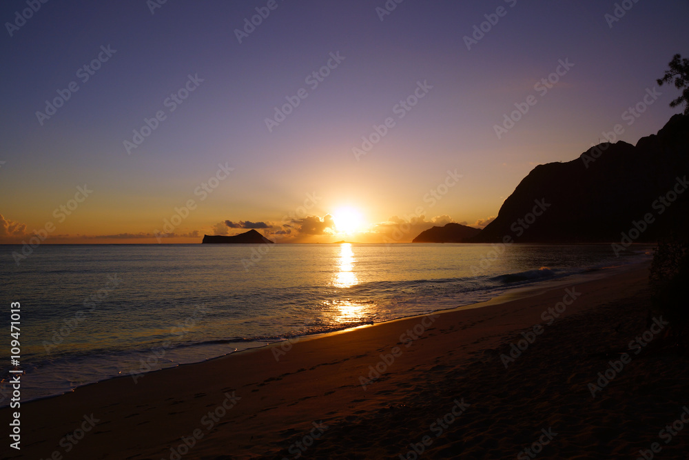 Naklejka premium Early Morning Sunrise on Waimanalo Beach over Rock Island bursti