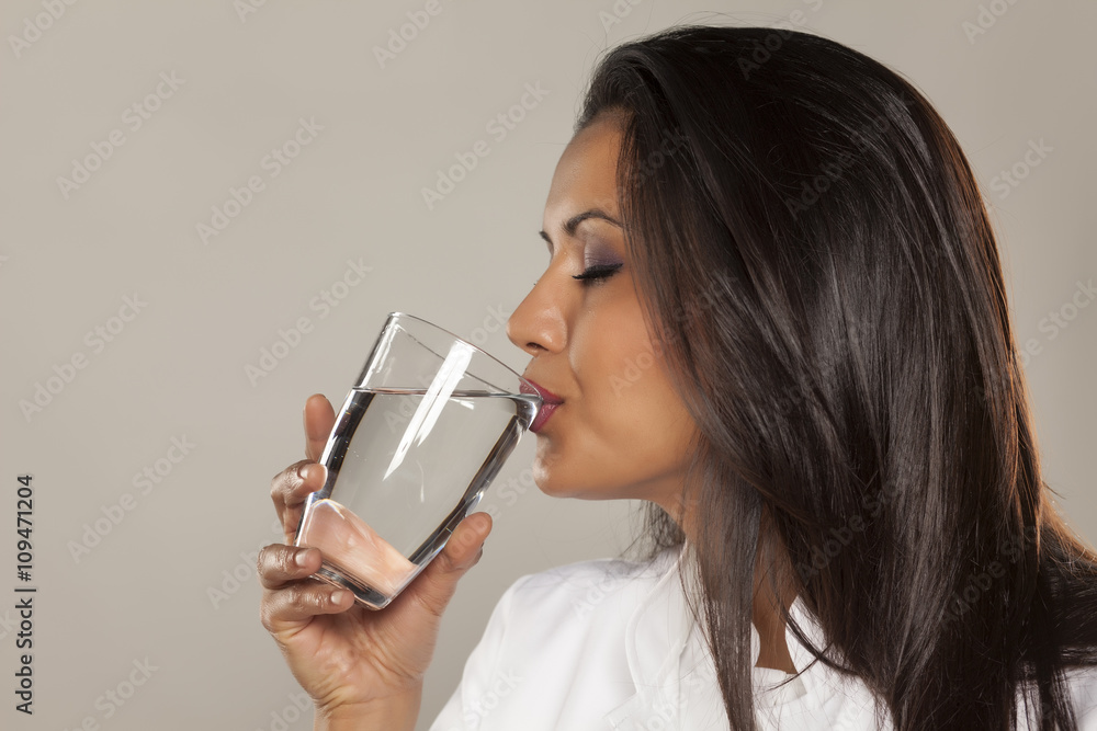 Woman doctor drinking a water from a glass Woman doctor drinking a water from a glass