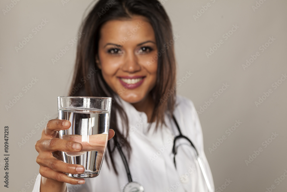 Smiling woman doctor holding a glass of water Smiling woman doctor holding a glass of water
