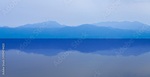 group of blue mountain layers with water reflection in Thailand © geargodz