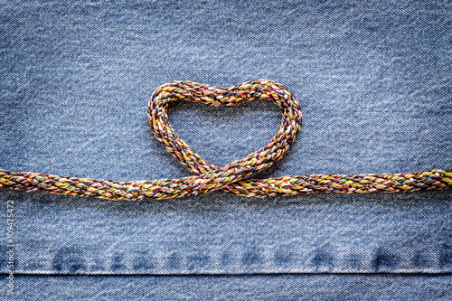 Love heart shaped rope on denim jeans background