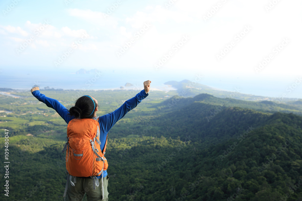 cheering successful woman hiker open arms at mountain peak cheering successful woman hiker open arms at mountain peak