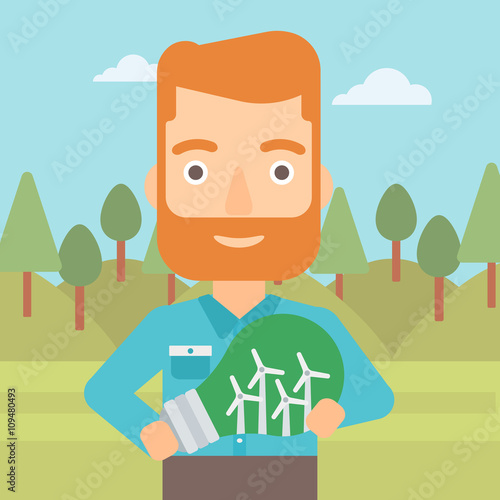 Man holding lightbulb with windmills inside.