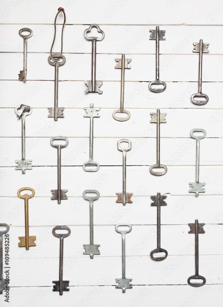 Some door keys aligned on old wooden surface, safety and security concept background Some door keys aligned on old wooden surface, safety and security concept background