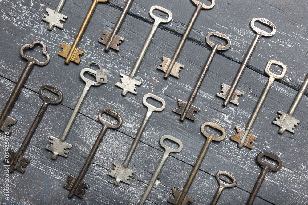 Some door keys aligned on old wooden surface, safety and security concept background Some door keys aligned on old wooden surface, safety and security concept background