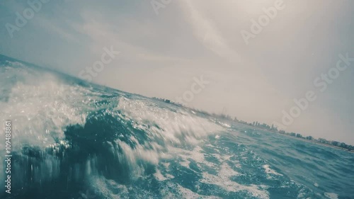 Waves and turbulence with bubbles in motion at sea level back view.