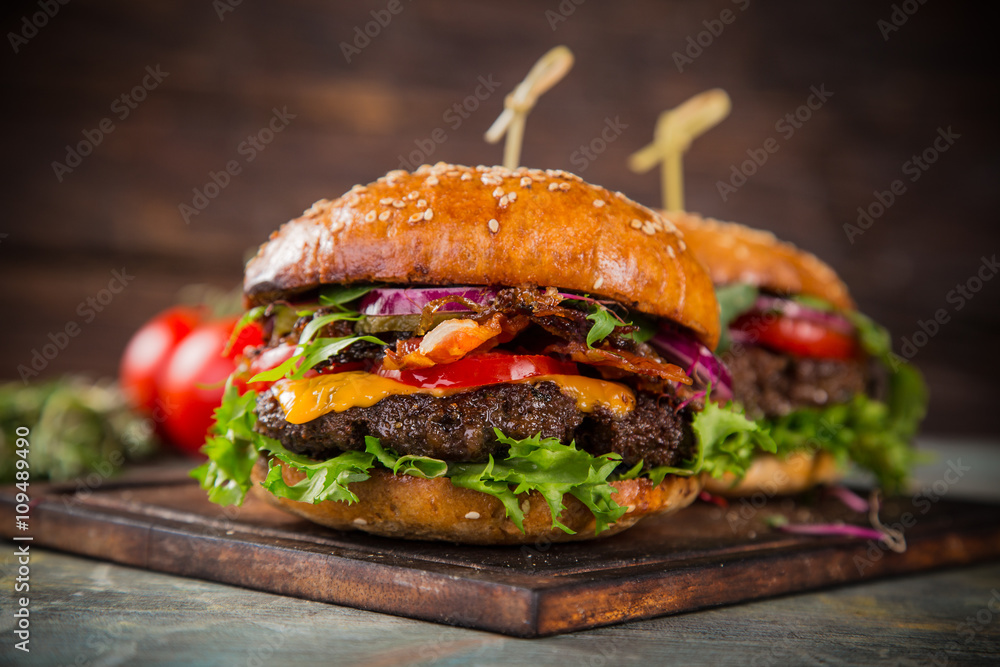 Tasty burgers on wooden table. - obrazy, fototapety, plakaty 
