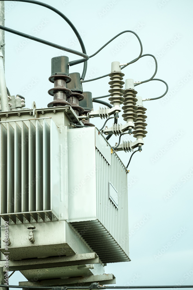 Energy and technology: electrical post by the road with power line cables, transformers and phone lines Energy and technology: electrical post by the road with power line cables, transformers and phone lines