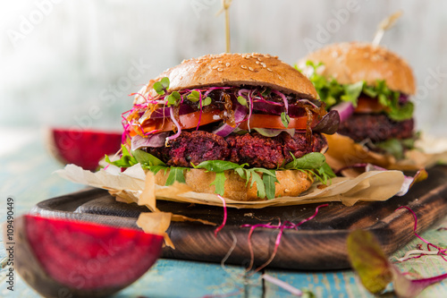 Tasty vegetarian beet burgers on wooden table.
