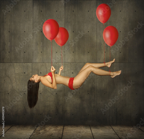 Photography A girl is flying on red balloons.