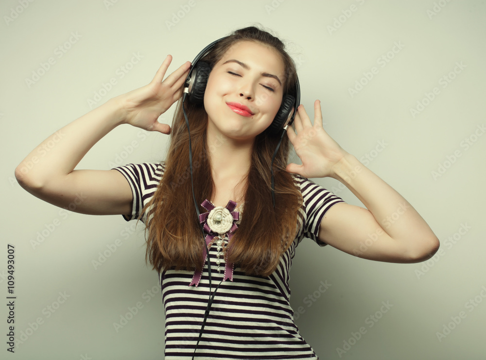 Fototapeta premium Young happy woman with headphones listening music 