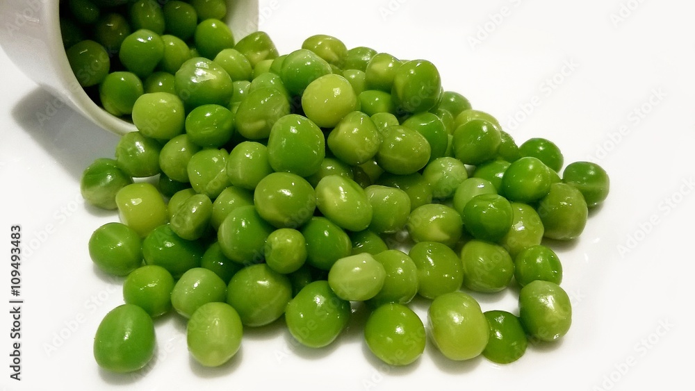 Isolated healthy fresh green peas scattered on white background Isolated healthy fresh green peas scattered on white background