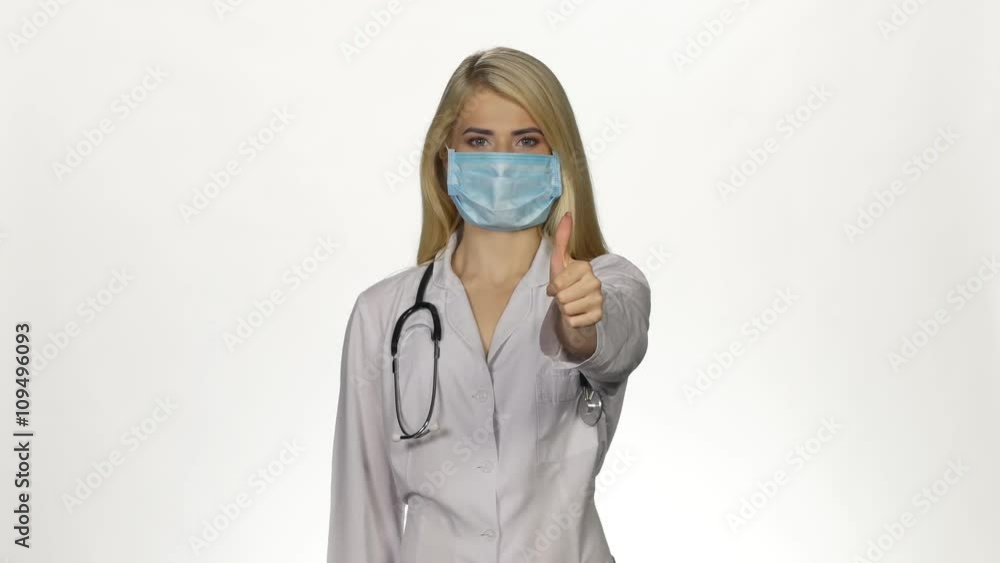 Female doctor making thumbs up sign. White Female doctor making thumbs up sign. White