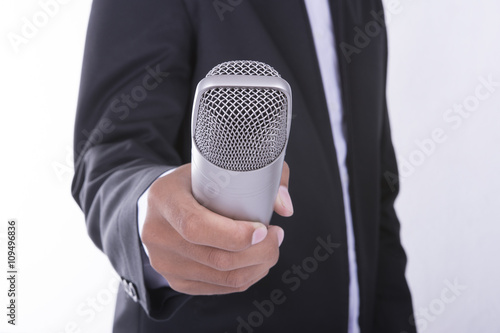 Man in business suit holding microphone - interview concept