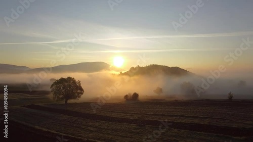 Aerial - Flying over the clouds at sunrise in the mountain 