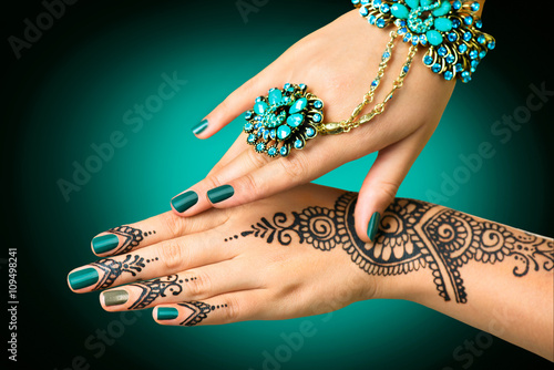 Woman's hands with mehndi tattoo. Hands of Indian bride girl with black henna tattoos