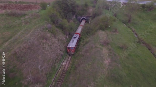 Train emerges from the tunnel / Drone follows it.