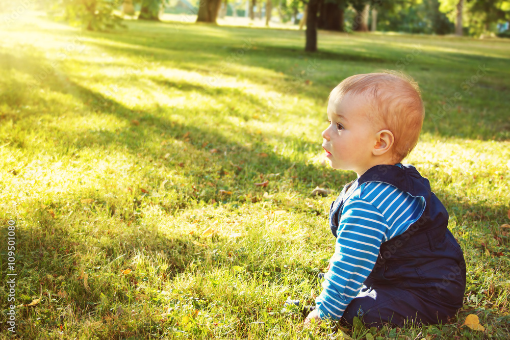 little boy sitting in the park