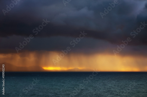 rain showers on the sea at sunset