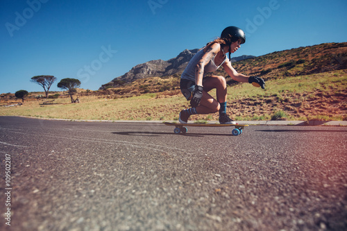 Young woman longboarding on a road