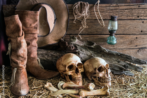 still life two human skull on hay with traditional leather boots and american...