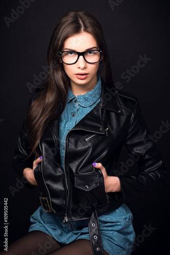 Beautiful young woman in glasses on a black background