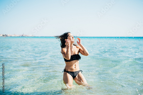 Knee figure of young handsome brasilian woman having a bath in the sea - summer, refreshing, holiday concept