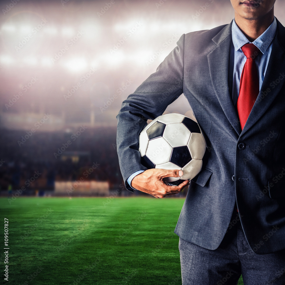 Naklejka premium soccer manager holding football in the stadium,closeup color process