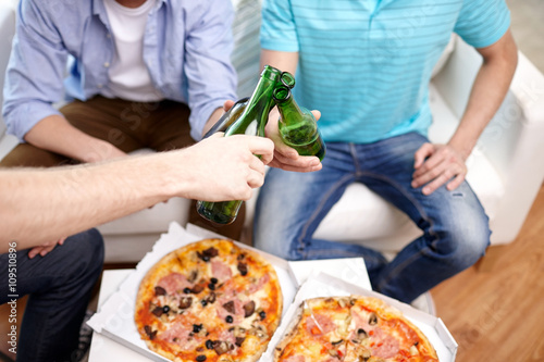 close up of male hands with beer and pizza at home